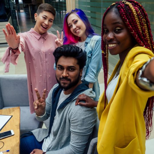 multiracial business group working taking selfie portrait on camera smartphone at modern office.