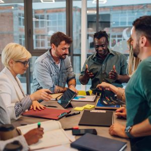 Multicultural professional project managers group negotiating in boardroom at meeting. Boss discussing with creative diverse team the concept of business strategy in their project. Fun at work.